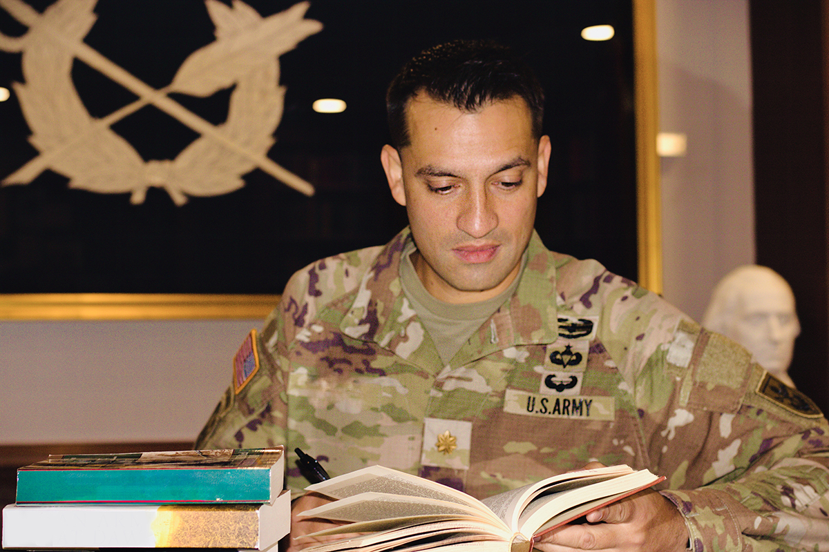 Soldier sitting at desk, pen in hand.